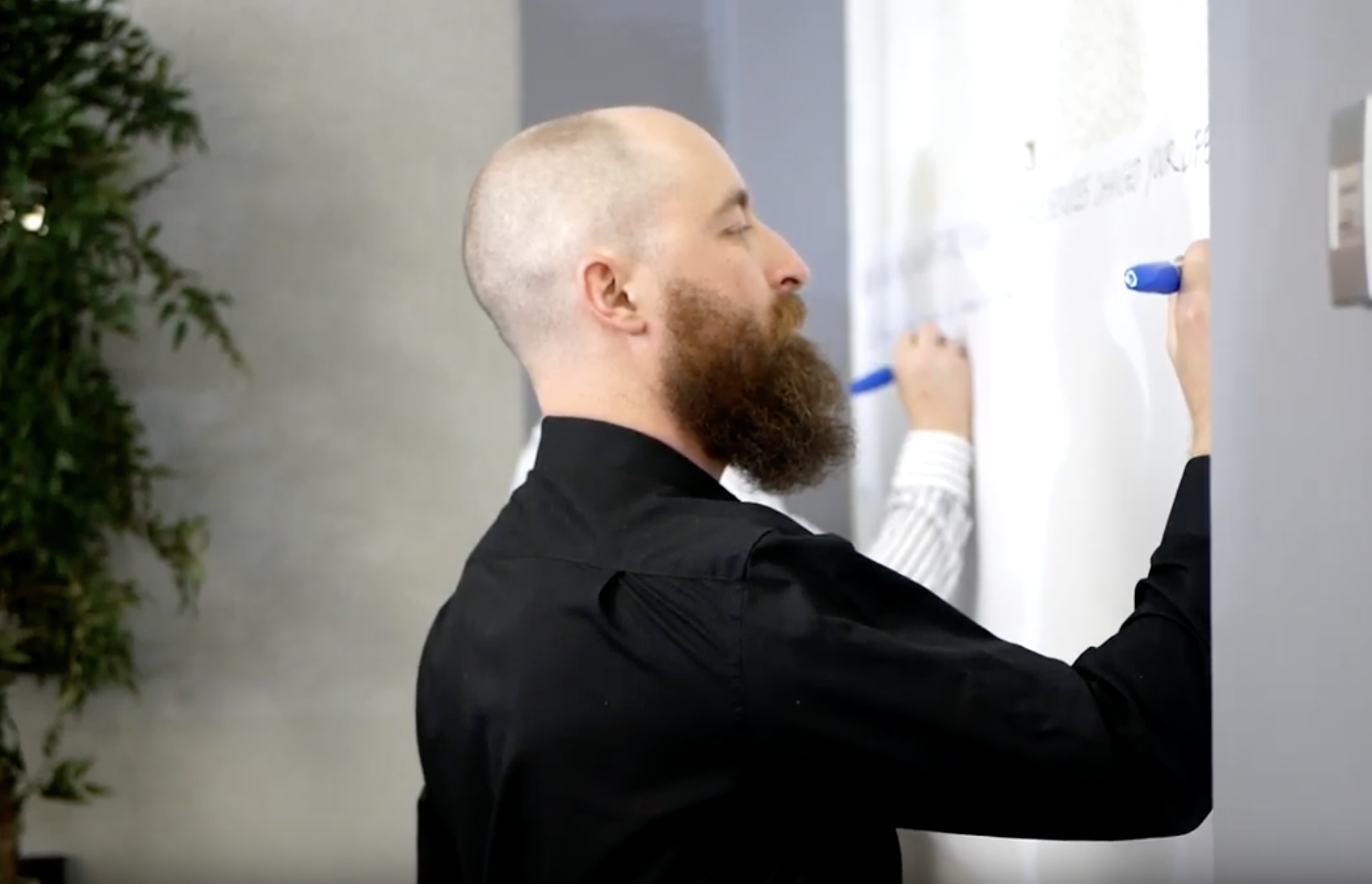 A student writes on a whiteboard with a marker